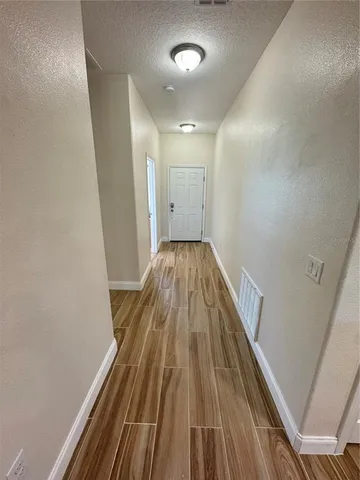 a view of a hallway with wooden floor