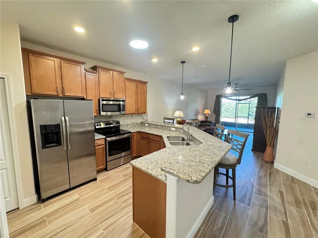 a kitchen with kitchen island granite countertop wooden floors and stainless steel appliances