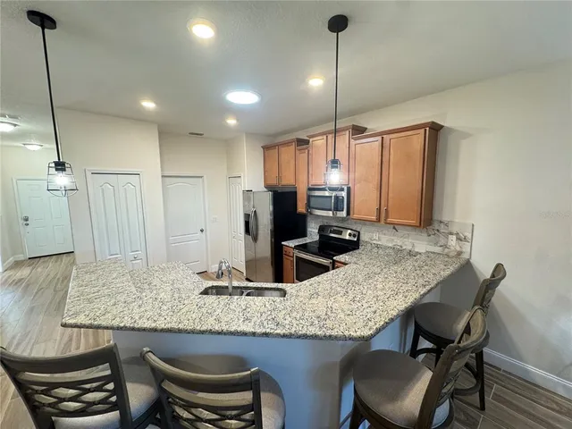 a kitchen with granite countertop kitchen island stainless steel appliances a table and chairs