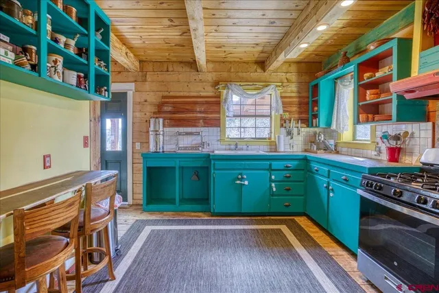 a kitchen with stainless steel appliances granite countertop a stove and a wooden floors