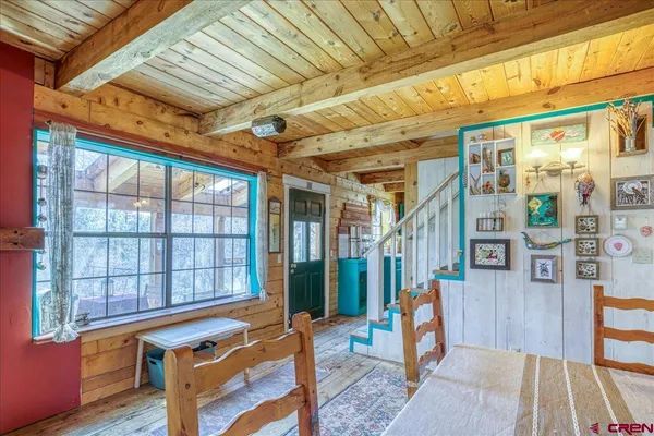 a view of an empty room with wooden floor and a windows