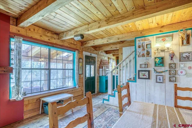 a view of an empty room with wooden floor and a windows