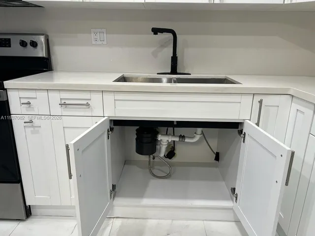 a vase of flowers sitting on a floor in front of a house