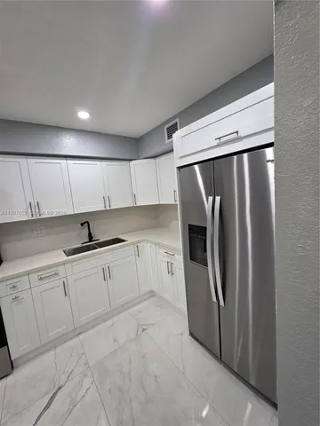 a living room with couches and kitchen view