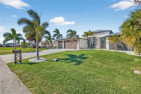 a view of a house with a big yard and palm trees