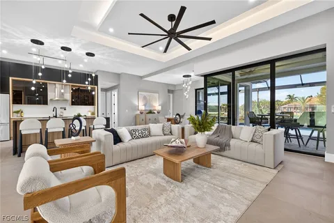 a living room with furniture ceiling fan and a large window