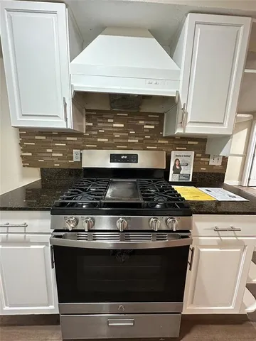 a stove top oven sitting inside of a kitchen
