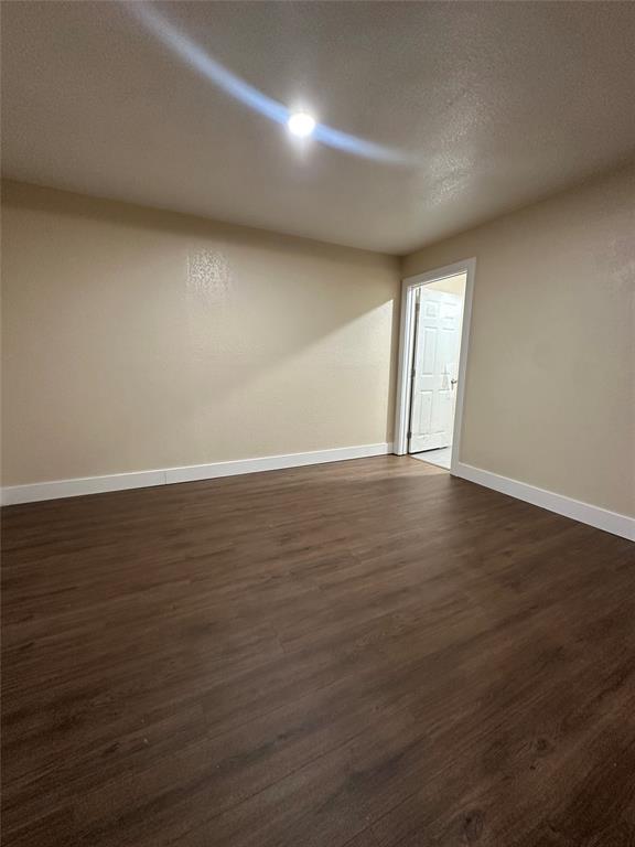 1609 Running River Road Garland, TX 75044 - Photo 17 of 37 a view of an empty room with wooden floor and a window
