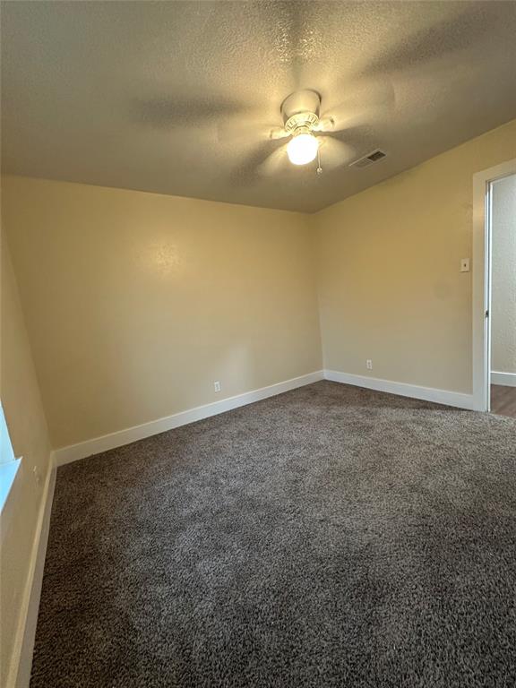 1609 Running River Road Garland, TX 75044 - Photo 25 of 37 an empty room with a chandelier fan and windows