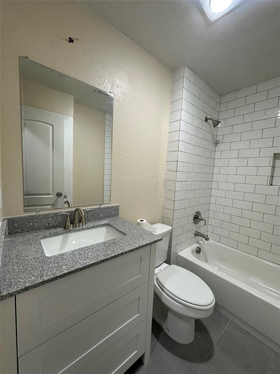 1609 Running River Road Garland, TX 75044 - Photo 26 of 37 a bathroom with a granite countertop toilet a sink and a bathtub