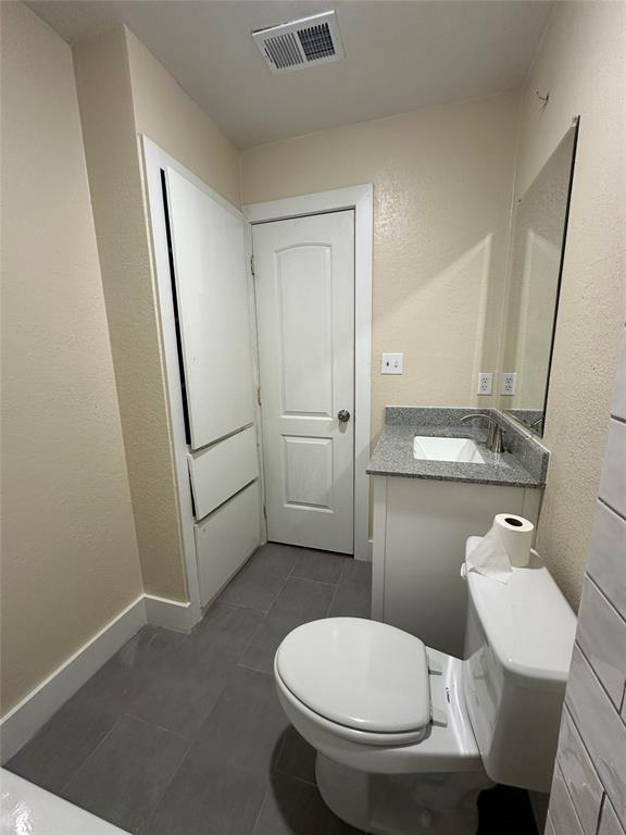 1609 Running River Road Garland, TX 75044 - Photo 28 of 37 a white toilet sitting next to a bathroom sink and a mirror