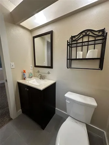 a bathroom with a sink vanity mirror and toilet