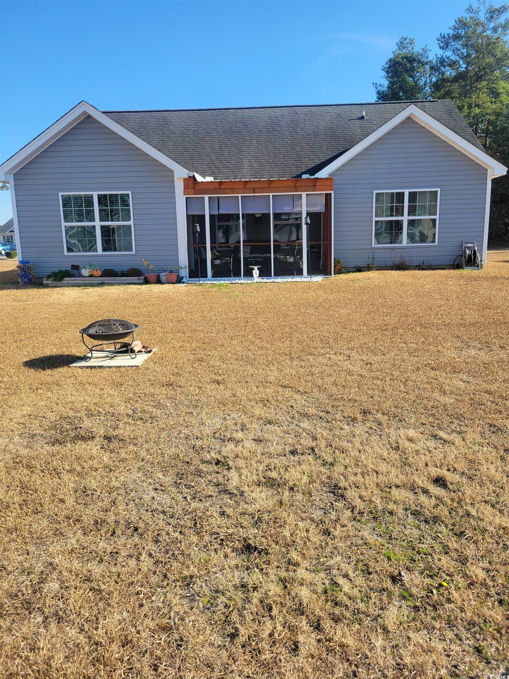 405 Beulah Circle Conway, SC 29527 - Photo 24 of 28 Back of property with an outdoor fire pit, a sunroom, a yard, and roof with shingles