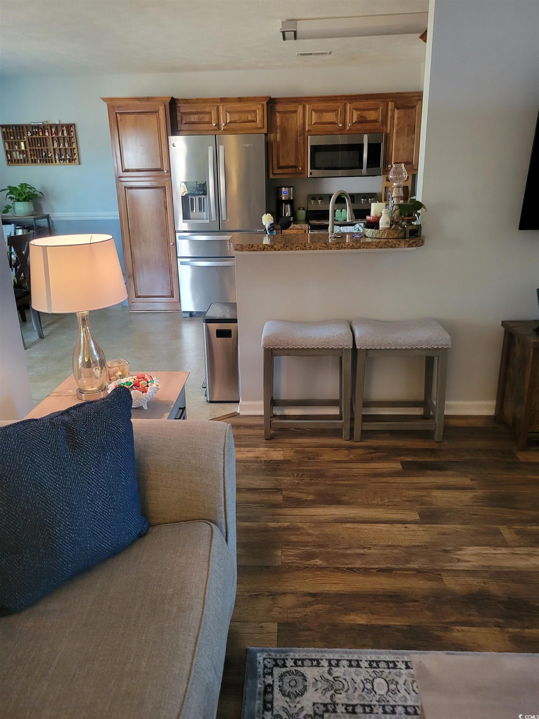 405 Beulah Circle Conway, SC 29527 - Photo 6 of 28 Kitchen with appliances with stainless steel finishes, brown cabinets, a peninsula, a breakfast bar area, and dark wood finished floors