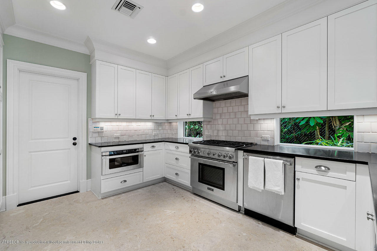165 Root Trail Palm Beach, FL 33480 - Photo 13 of 39 a kitchen with white cabinets and white appliances