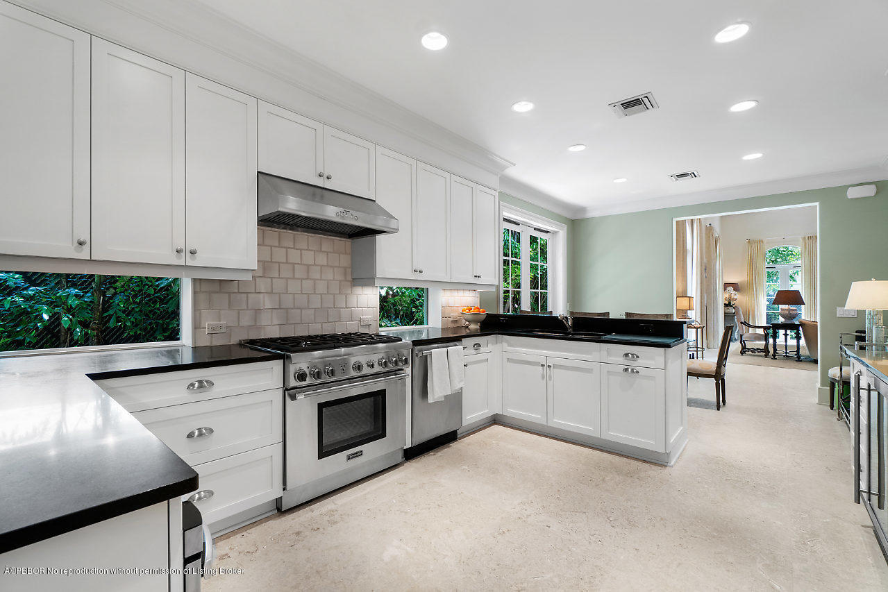 165 Root Trail Palm Beach, FL 33480 - Photo 14 of 39 a kitchen with granite countertop a stove sink and cabinets