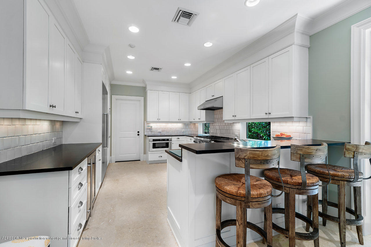 165 Root Trail Palm Beach, FL 33480 - Photo 16 of 39 a kitchen with stainless steel appliances kitchen island granite countertop a stove a sink a microwave and a refrigerator