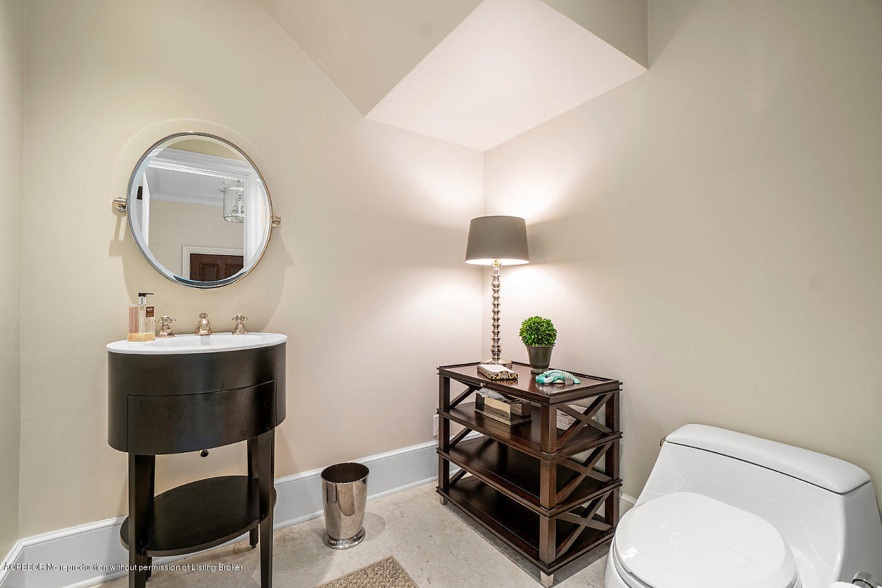 165 Root Trail Palm Beach, FL 33480 - Photo 17 of 39 a bathroom with a toilet a sink and mirror