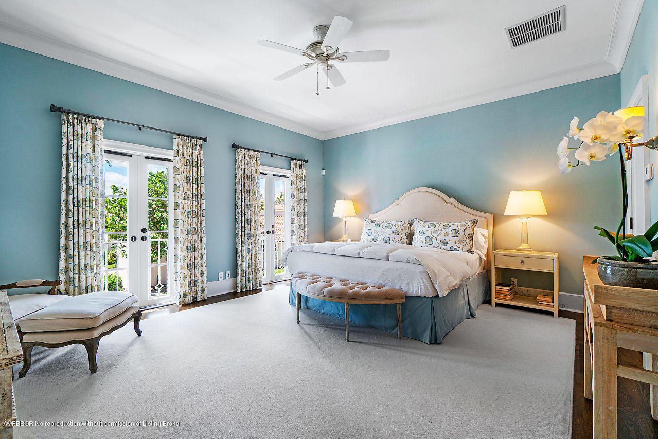 165 Root Trail Palm Beach, FL 33480 - Photo 19 of 39 a spacious bedroom with a bed and a chandelier