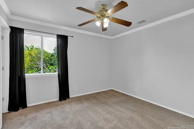 an empty room with a window and a fan