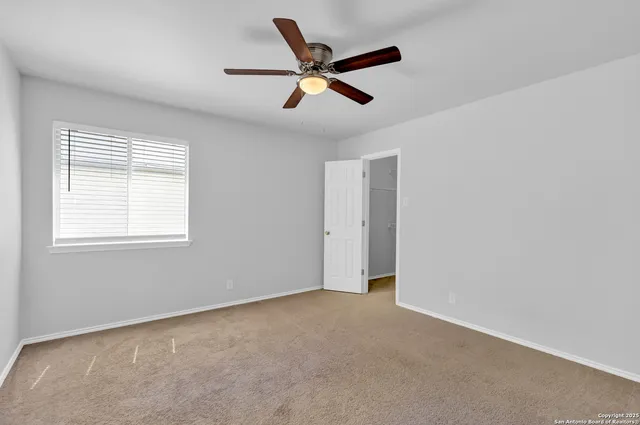 a view of an empty room with a ceiling fan