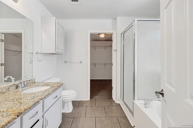a bathroom with a granite countertop sink toilet and shower