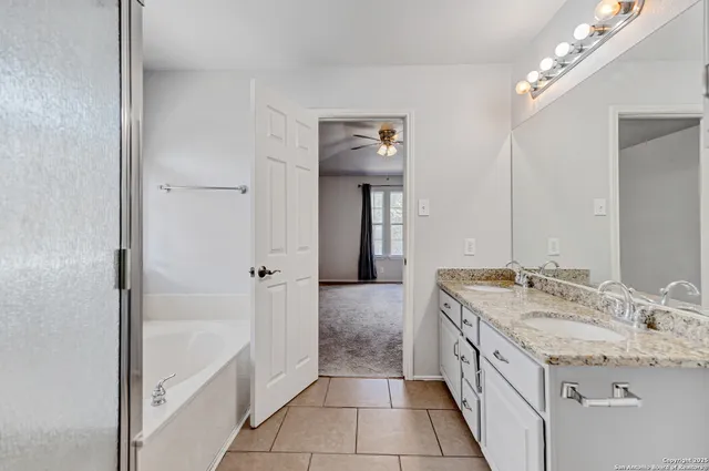 a bathroom with a granite countertop sink a toilet and a mirror