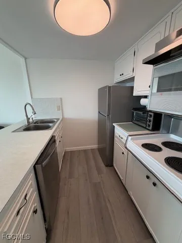 a kitchen with a sink a refrigerator and a stove