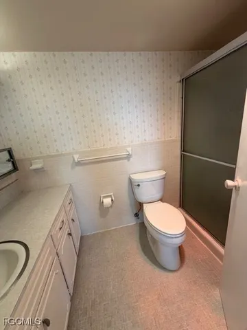 a white toilet sitting next to a bathroom sink