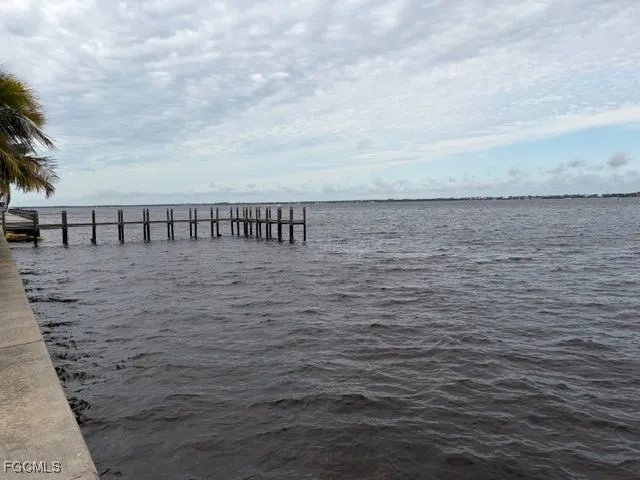 a view of swimming pool with lawn chairs and iron fence
