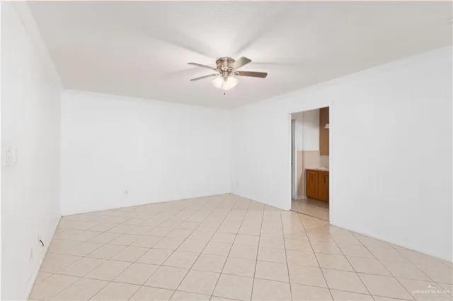 an empty room with fan and windows