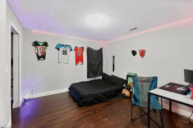 a bedroom with furniture and a wooden floor