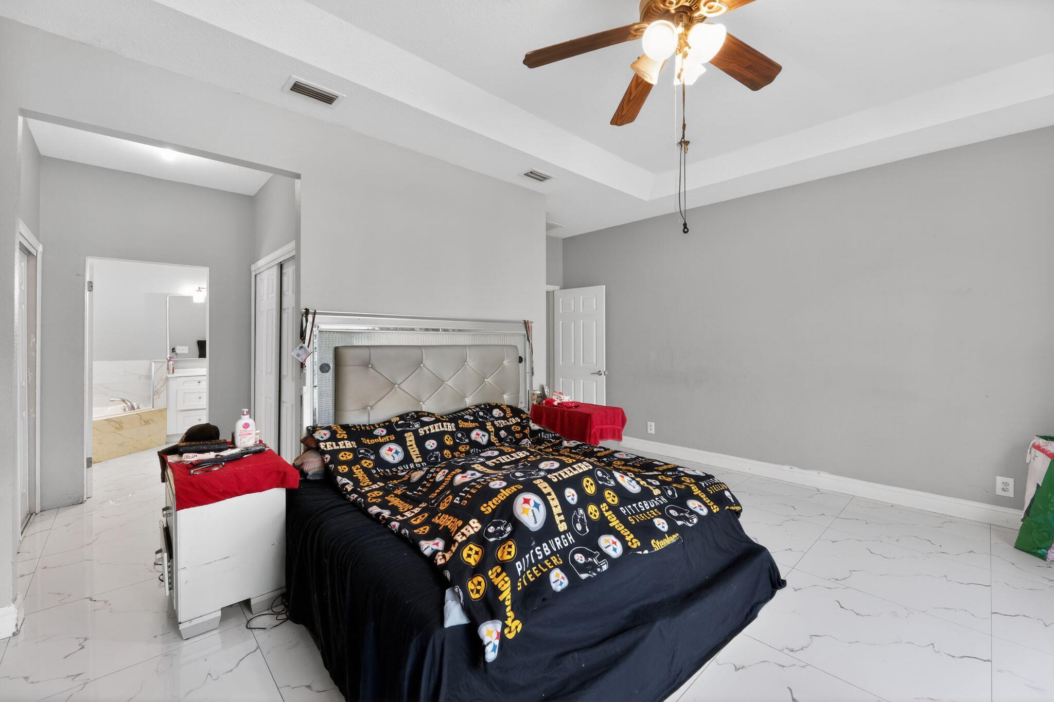 16875 68th Street North Loxahatchee, FL 33470 - Photo 14 of 26 a bedroom with a bed and a chandelier