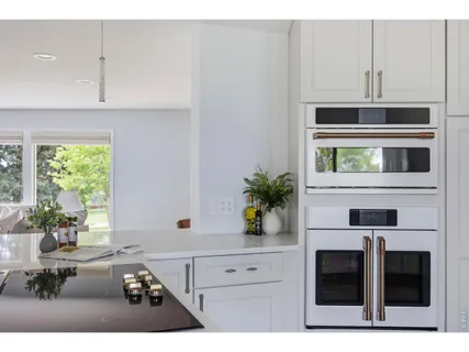 a kitchen with stainless steel appliances a white stove top oven and a white cabinets