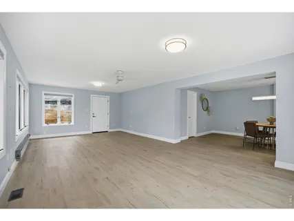 a view of empty room with window and wooden floor