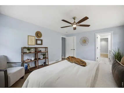 a bedroom with a bed a couch and a chandelier