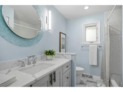 a bathroom with a granite countertop sink a toilet and a mirror