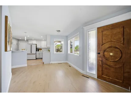 a view of empty room with kitchen and window