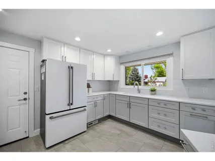 a kitchen with stainless steel appliances a refrigerator sink and white cabinets