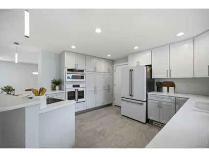 a kitchen with white cabinets and stainless steel appliances