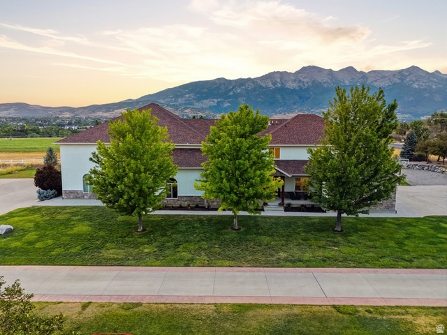 702 Alpine Highway Alpine, UT 84004 - Photo 8 of 83 Expansive residence featuring a stucco and stone facade, a rich red-brown shingle roof, and a verdant lawn