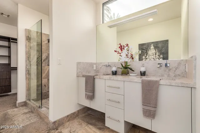 a bathroom with a granite countertop sink a mirror and a shower