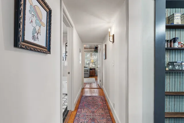 a view of a hallway with wooden floor and closet