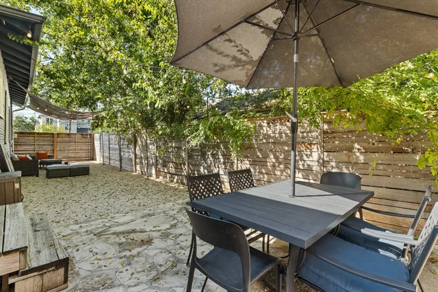 a view of a patio with table and chairs under an umbrella