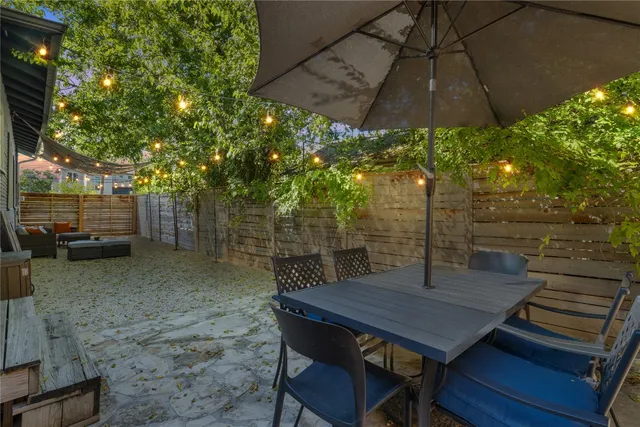 a view of a patio with table and chairs under an umbrella