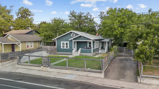 a front view of house with yard and trees in the background
