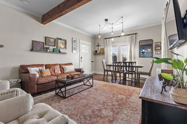 a living room with furniture a chandelier and a dining table