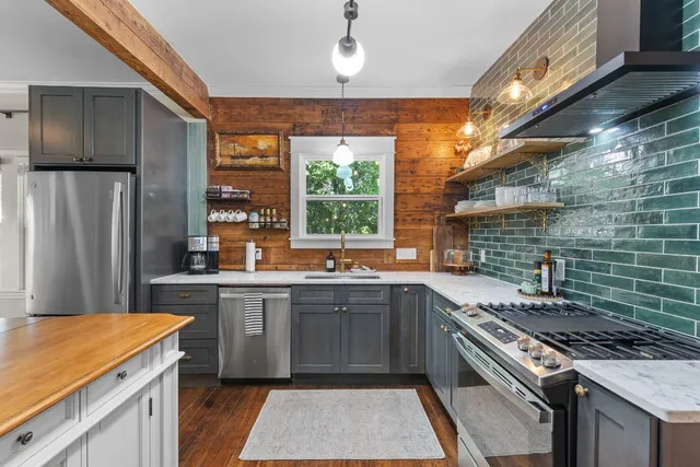 a kitchen with stainless steel appliances a stove sink and cabinets
