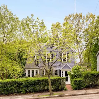 a front view of a house with a garden