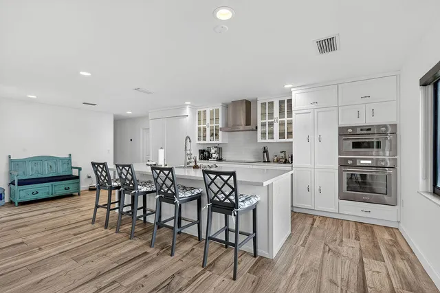 a kitchen with a dining table chairs and white cabinets